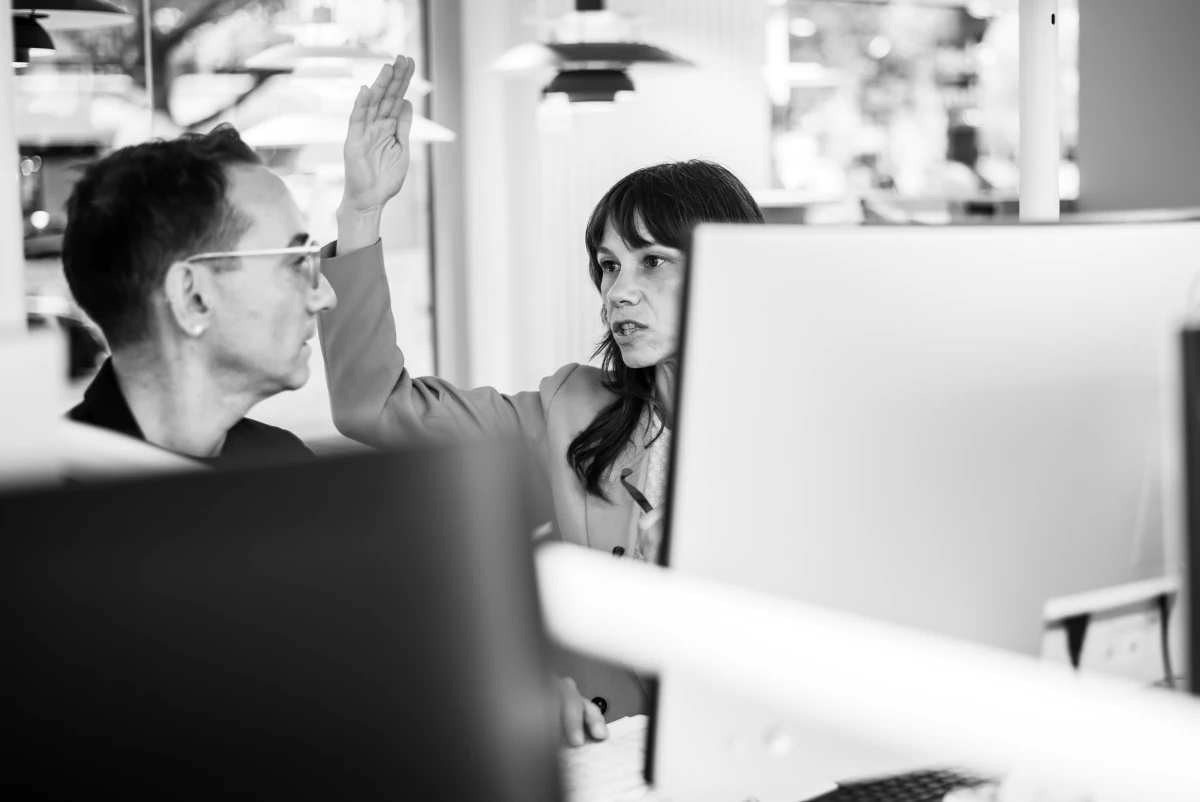 Reportagefotografie Mitarbetier Arbeitsalltag Vor Monitor Diskussion